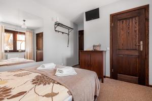 a bedroom with a bed and a wooden door at Willa Parys in Władysławowo