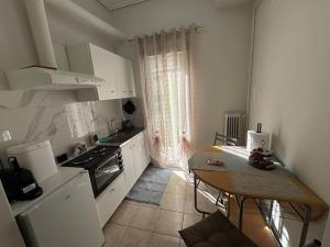 a kitchen with white cabinets and a table in it at Evann's sweet home in Larisa +5 photos