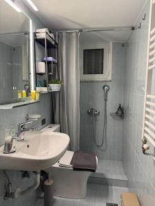 a white bathroom with a sink and a shower at Evann's sweet home in Larisa