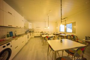 a large kitchen with tables and chairs in it at Santa's winter Caravan-Kabe Smaragd in Rovaniemi