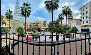 Una vista de una ciudad con palmeras y edificios. en Suites Plaza Alta, en Algeciras