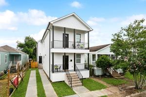 a white house with a staircase in the front yard at Elegant 5-Bedroom NOLA Getaway in New Orleans
