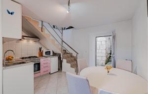 a kitchen with a white table and a white counter top at One-Bedroom Apartment In Racisce in Račišće