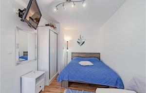 a bedroom with a bed with a blue comforter at One-Bedroom Apartment In Racisce in Račišće