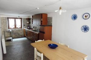 a kitchen with a wooden table with a blue bowl on it at Maison du Milieu in Salbertrand