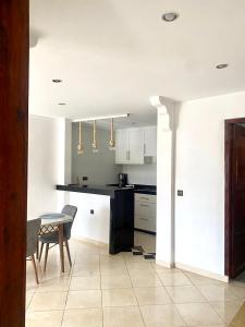 a kitchen with a counter and a table and chairs at Appartement City Agadir 2 in Agadir +22 photos