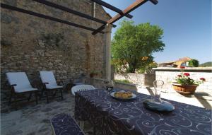 a table with a plate of fruit on a patio at Three-Bedroom Holiday Home In Blato in Blato