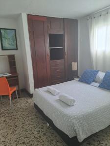 a bedroom with a bed with a desk and a chair at VIVIENDA TURISTICA Grand Royal Inn in Barranquilla