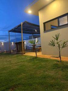 a house with a blue umbrella on the side of it at Recanto Lambari da Canastra in Delfinópolis +9 photos
