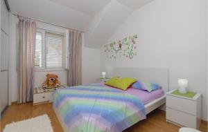 une chambre avec un lit arc-en-ciel et un ours en peluche dans l'établissement Three-Bedroom Apartment In Racisce, à Račišće