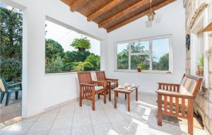 patio z krzesłami, stołem i oknami w obiekcie 2 Bedroom Awesome Home In Vodnjan w mieście Vodnjan +28 zdjęć