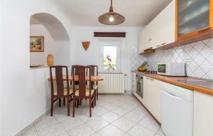 kuchnia ze stołem, 2 krzesłami i stołem w obiekcie 2 Bedroom Awesome Home In Vodnjan w mieście Vodnjan