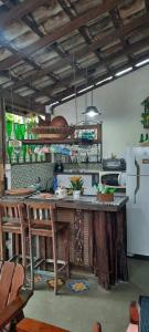 a kitchen with a counter and a white refrigerator at Chalé Puertas y Ventanas in São Sebastião
