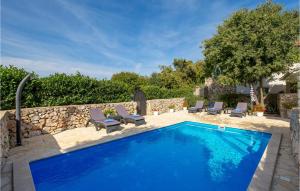 ein Swimmingpool in einem Hof mit Stühlen und einer Steinmauer in der Unterkunft Nice Apartment In Garica With Wifi in Garica + 26 Fotos