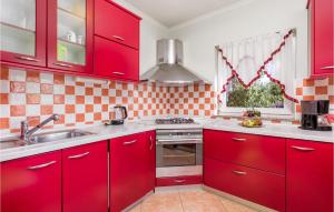 eine Küche mit roten Schränken und einer Spüle in der Unterkunft Nice Apartment In Garica With Wifi in Garica