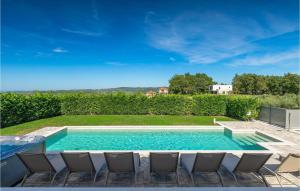 a swimming pool with chairs in a yard at Villa Edoardo in Vižinada