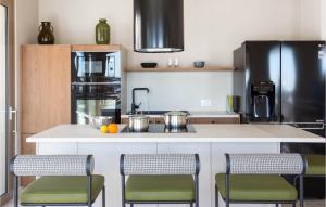 eine Küche mit einer Theke mit Stühlen und einem Kühlschrank in der Unterkunft Pet Friendly Home In Rogoznica in Rogoznica