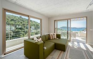 ein Wohnzimmer mit einem grünen Sofa und großen Fenstern in der Unterkunft Pet Friendly Home In Rogoznica in Rogoznica