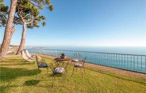 Una mesa y sillas sobre el césped cerca del océano. en 3 Bedroom Cozy Home In Arenys De Mar, en Arenys de Mar