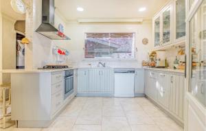 Una cocina con gabinetes blancos y una ventana. en 3 Bedroom Cozy Home In Arenys De Mar, en Arenys de Mar