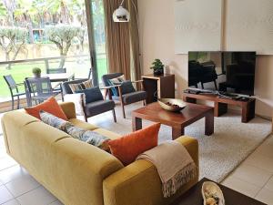 a living room with a couch and a television at Charming apartment Herdade dos Salgados - Vila das Lagoas T2 in Guia