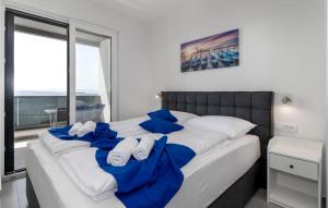 a bedroom with a large bed with blue and white pillows at Gorgeous Home In Dramalj in Dramalj