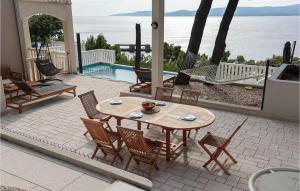 eine Terrasse mit Tisch und Stühlen und einem Pool in der Unterkunft Beautiful Apartment In Lokva Rogoznica in Lokva Rogoznica