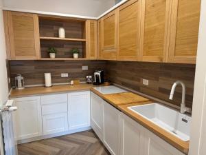 a kitchen with wooden cabinets and a sink at Finestra Sul Borgo in Trevignano Romano