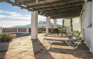 a patio with a table and chairs and a pool at 2 Bedroom Amazing Home In Frigiliana in Frigiliana +9 photos