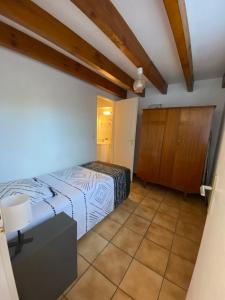 a bedroom with a bed and a cabinet at Maison à 800m de la plage classée 1 étoile in Capbreton