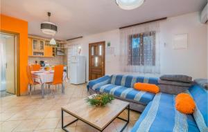 a living room with a blue couch and a table at Stunning Apartment In Njivice With Wifi in Njivice