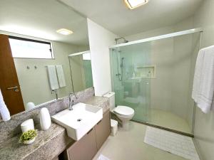 a bathroom with a sink and a shower and a toilet at Bangalô Exclusivo A5 no Cond Imbassaí Privilege Beira Mar in Imbassai