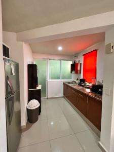 a large kitchen with a refrigerator and a sink at Apartamento inn cancun in Cancún
