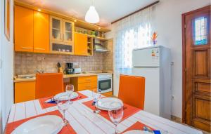a kitchen with a table and chairs and a refrigerator at Stunning Apartment In Njivice With Wifi in Njivice