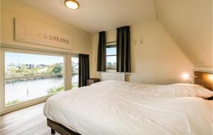 Un dormitorio con una cama grande y una ventana grande. en Grote Wiedenwoning 6P, en Giethoorn