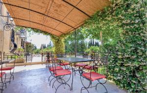 a table and chairs on a patio with a wall of ivy at Lovely Home In Vallabregues in Vallabrègues