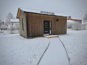 a small building with a door in the snow at Gårdshuset på Grubbe in Umeå