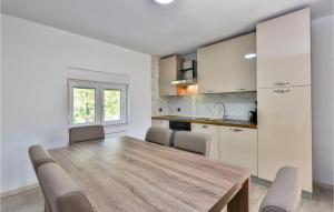 a kitchen and dining room with a wooden table and chairs at Lovely Home In Stikada With Sauna in Štikada