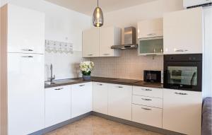 une cuisine blanche avec des armoires et des appareils blancs dans l'établissement 3 Bedroom Cozy Apartment In Marina, à Marina