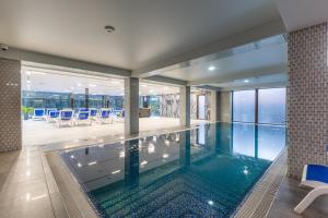 una piscina en un edificio con sillas azules en MARION Family Resort, en Bukovel