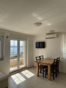 een eetkamer met een tafel en uitzicht op de oceaan bij Apartments KARLO in Baška Voda