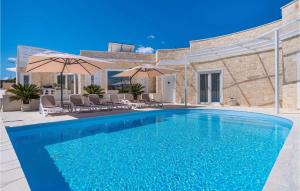 a blue swimming pool with chairs and umbrellas at Feriatum Lissa in Zadar +52 photos