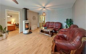 a living room with a leather couch and a fireplace at 5 Bedroom Nice Home In Båstad in Båstad