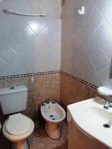a bathroom with a toilet and a sink at Triplex cerca del mar in San Bernardo