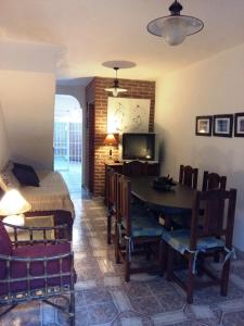 a room with a table and a bed and a television at Triplex cerca del mar in San Bernardo