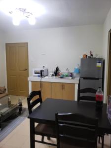 a kitchen with a black table and a refrigerator at Oceanview 2-bedroom Condo Unit in Dumaguete +7 photos