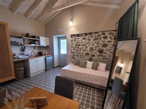 a bedroom with a bed in a room with a stone wall at Aelia Apartments Limnos in Thános
