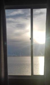 a window with a view of the ocean at Oceanview 2-bedroom Condo Unit in Dumaguete