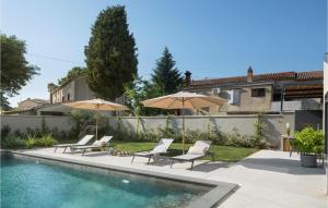 une piscine avec chaises longues et parasols à côté d'une maison dans l'établissement Villa Bino&Marija, à Poreč