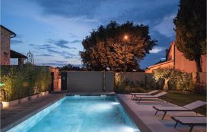 une cour arrière avec une piscine avec des chaises et une clôture dans l'établissement Villa Bino&Marija, à Poreč